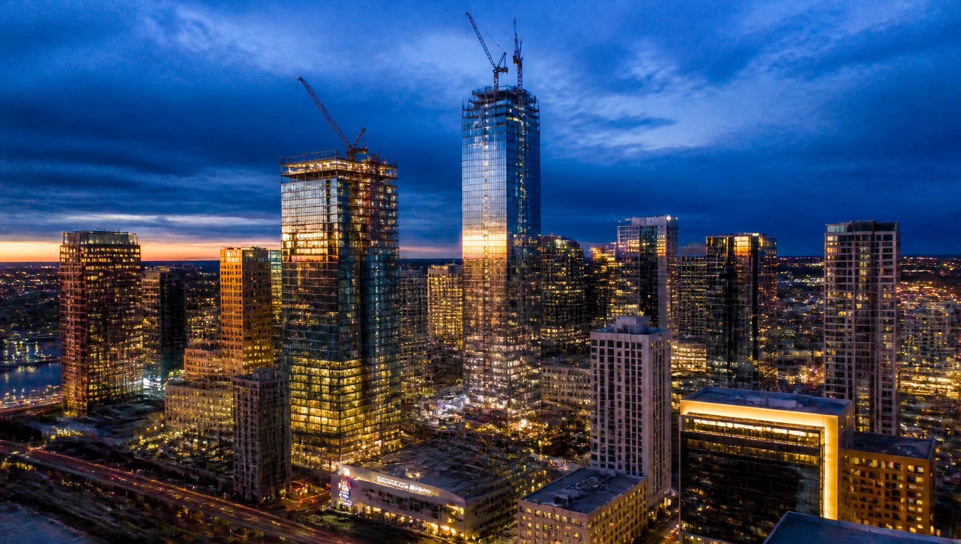 Aerial view of a city skyline with high-rise construction at dusk